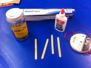 Wax paper (I bought the cheapest) Popsicle sticks (4) Glue Ribbon Glitter